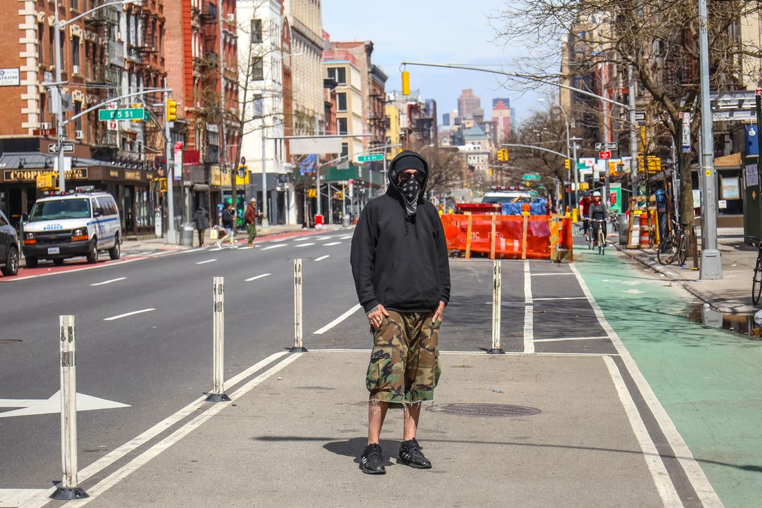 A man wearing a bandana face covering in the street